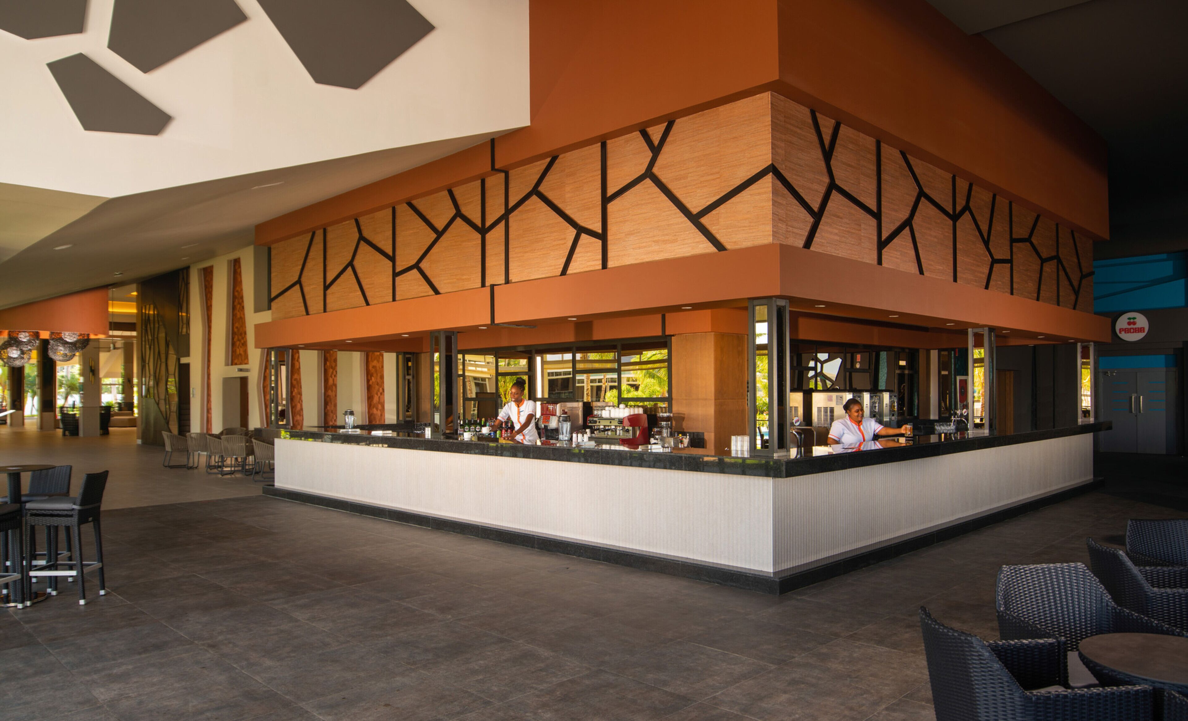 A modern bar area with a central counter, seating, and a view of the outdoors.