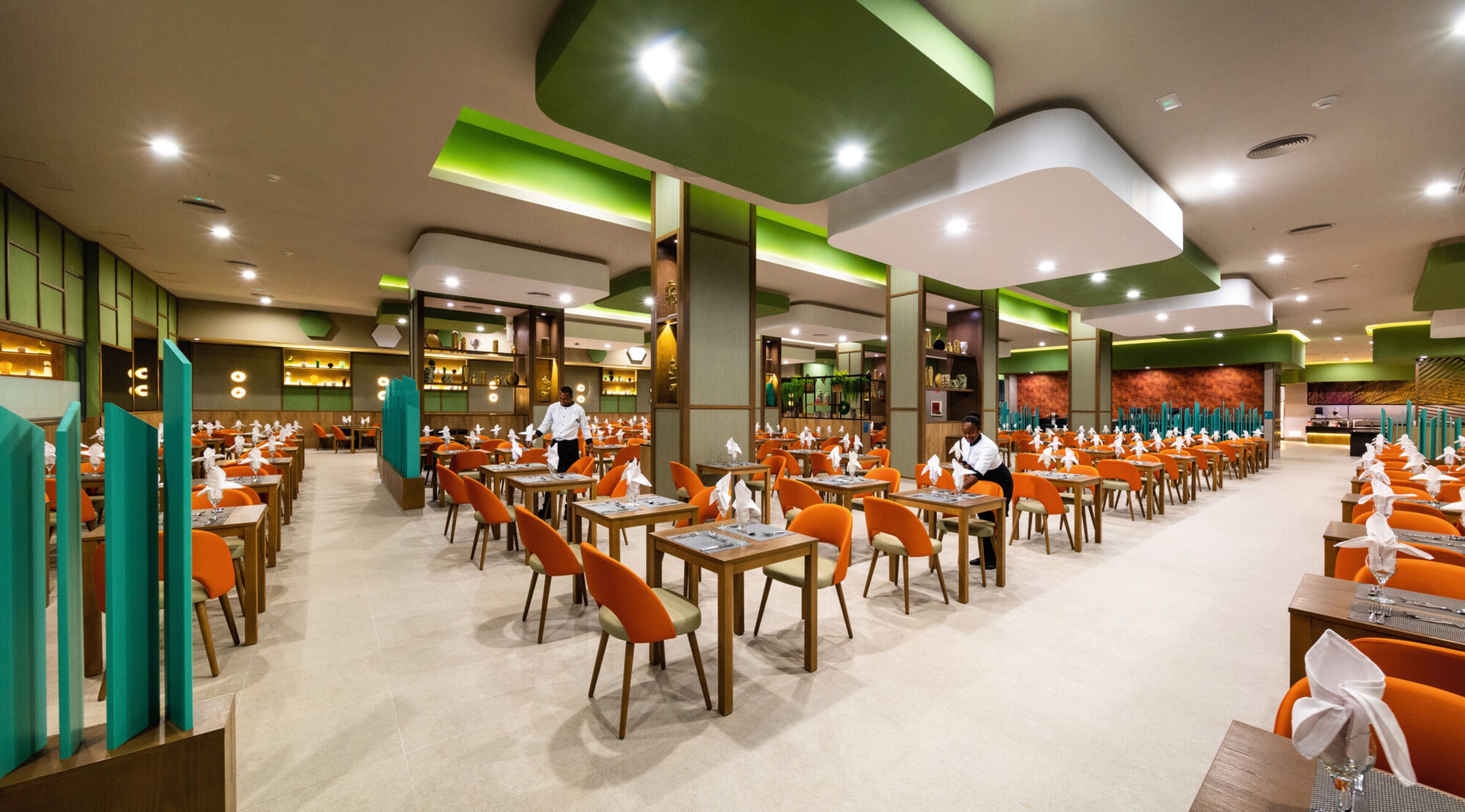 Un restaurante espacioso con varias zonas de comedor, cada una con mesas y sillas.