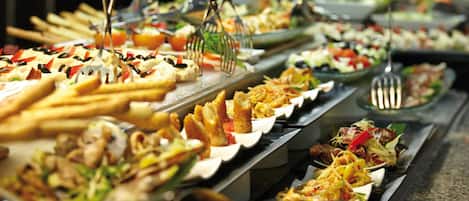 A buffet with various dishes and utensils.
