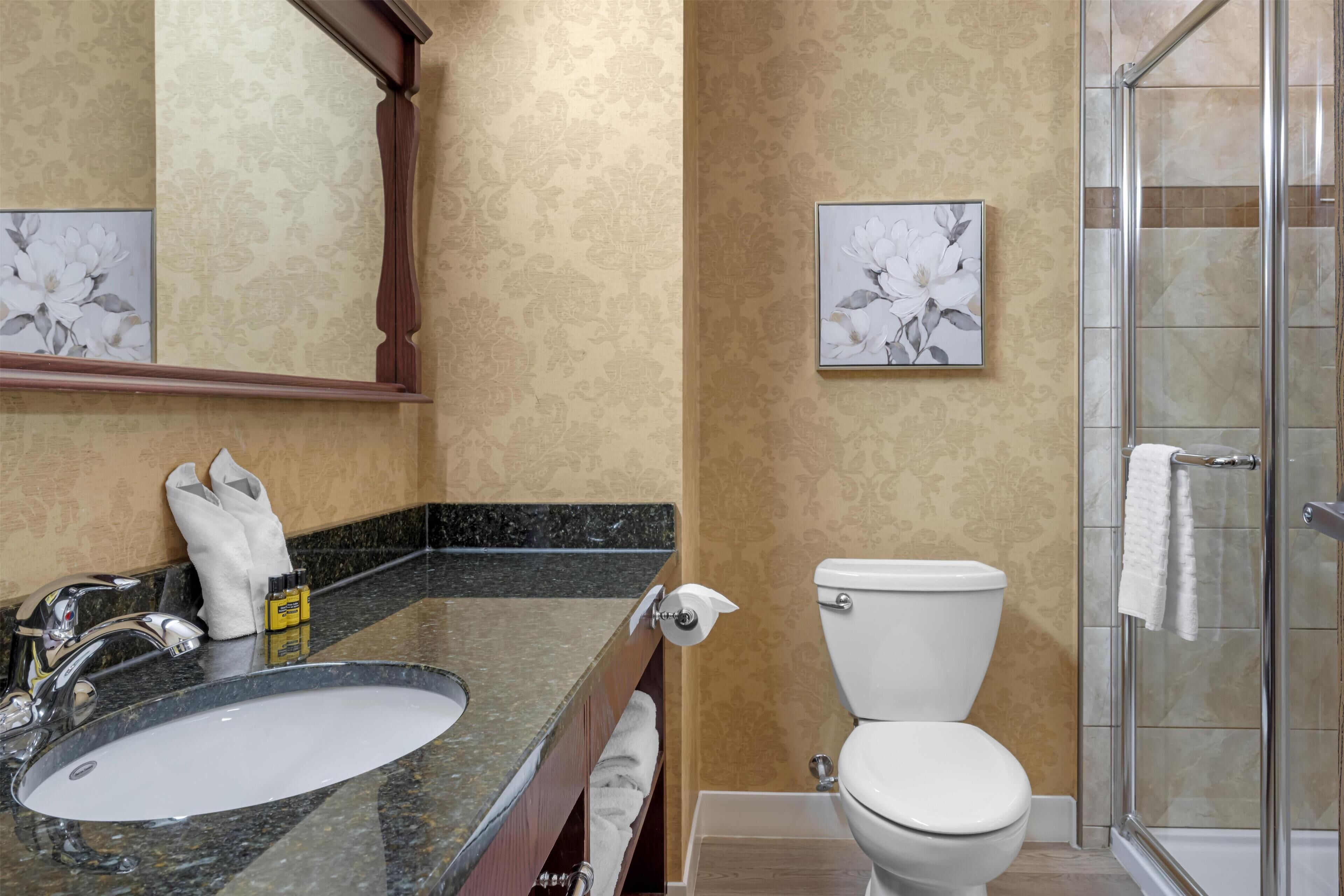 A bathroom with a sink, toilet, and shower.