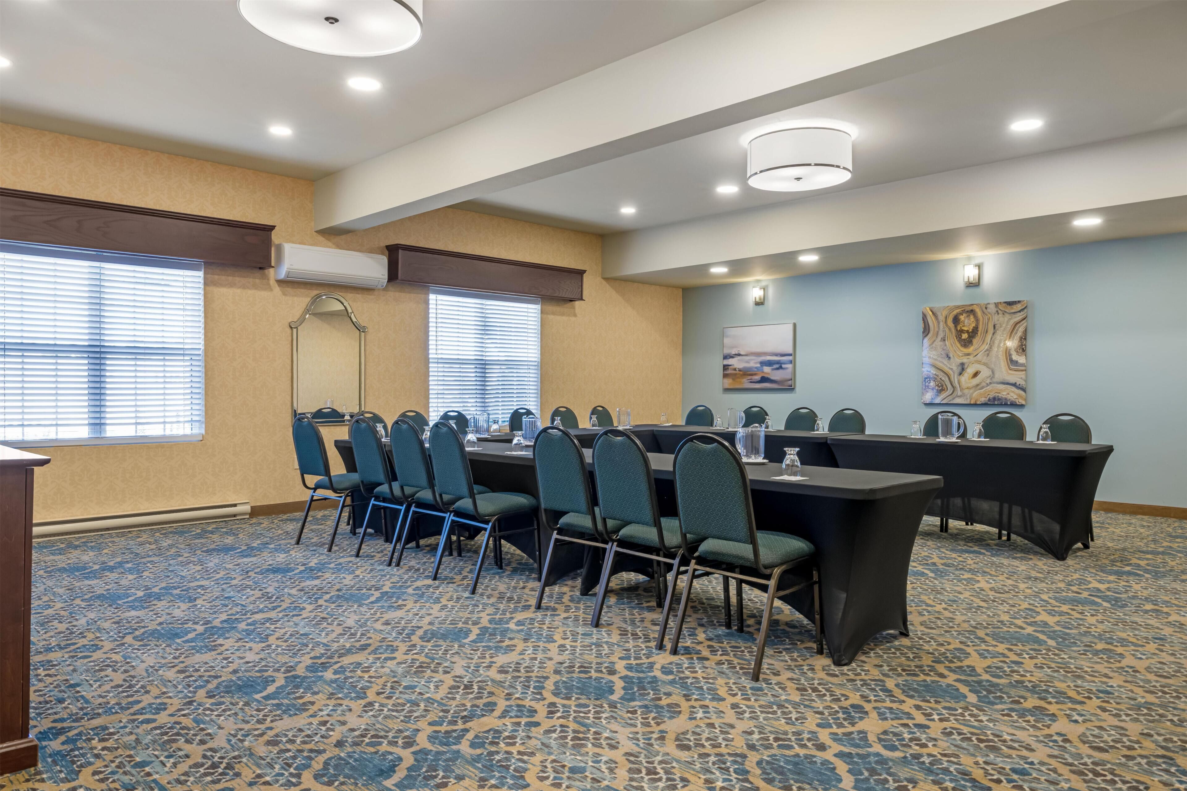 A conference room with a long table, chairs, and a podium.