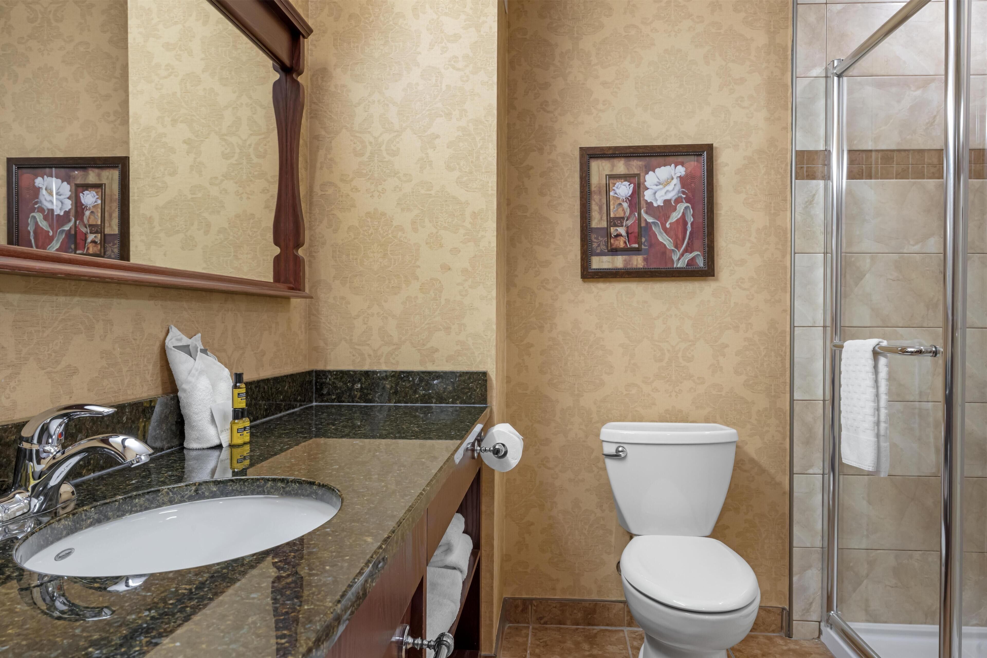 A bathroom with a sink, toilet, and shower.