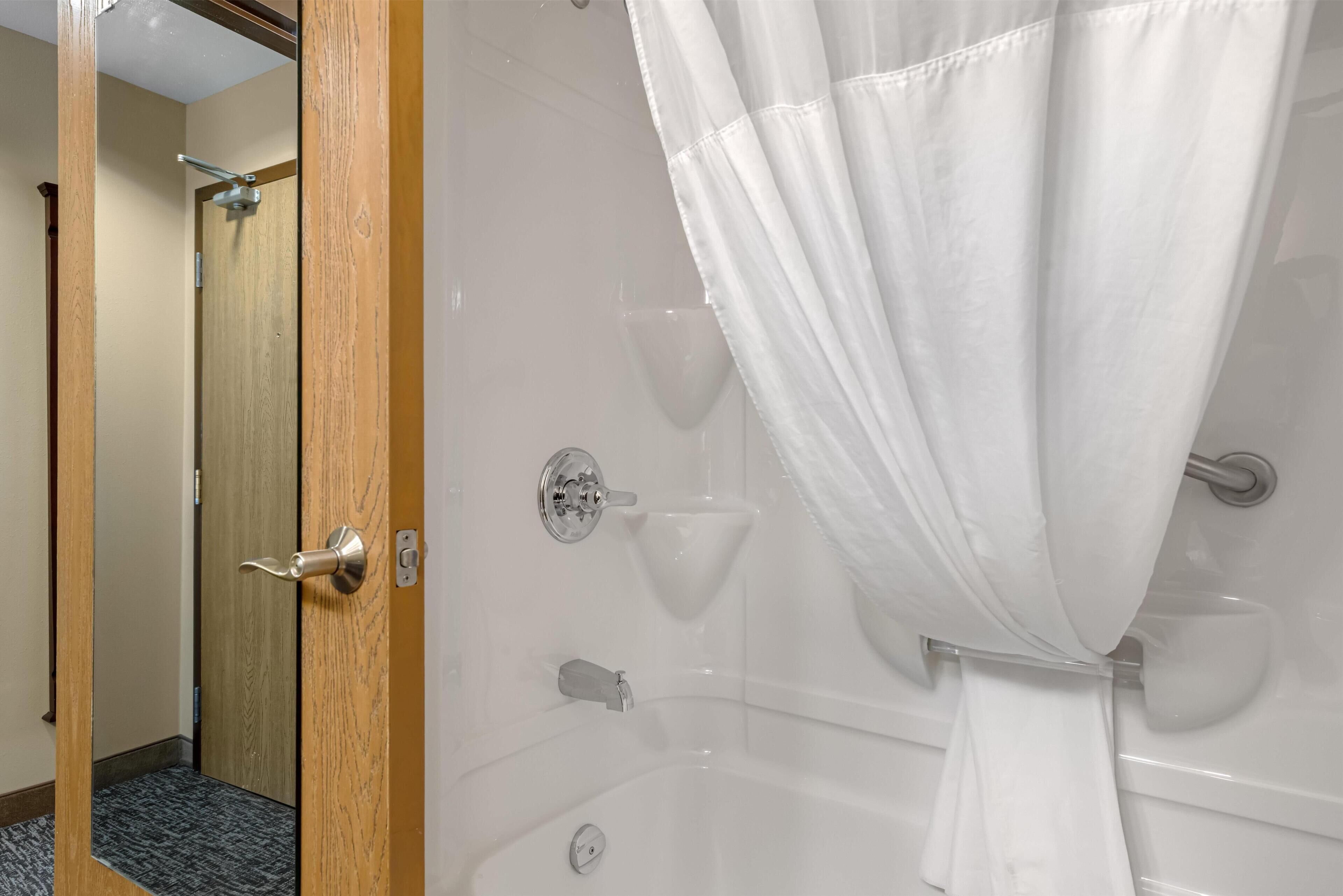 A bathroom with a shower, a toilet, and a sink.
