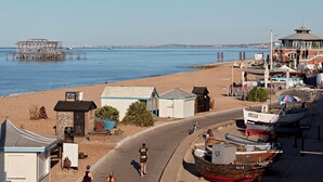Un pueblo costero con playa, barcos y un muelle.