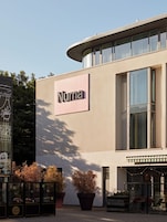 A building with a sign reading 'Numa' and a potted plant in front.