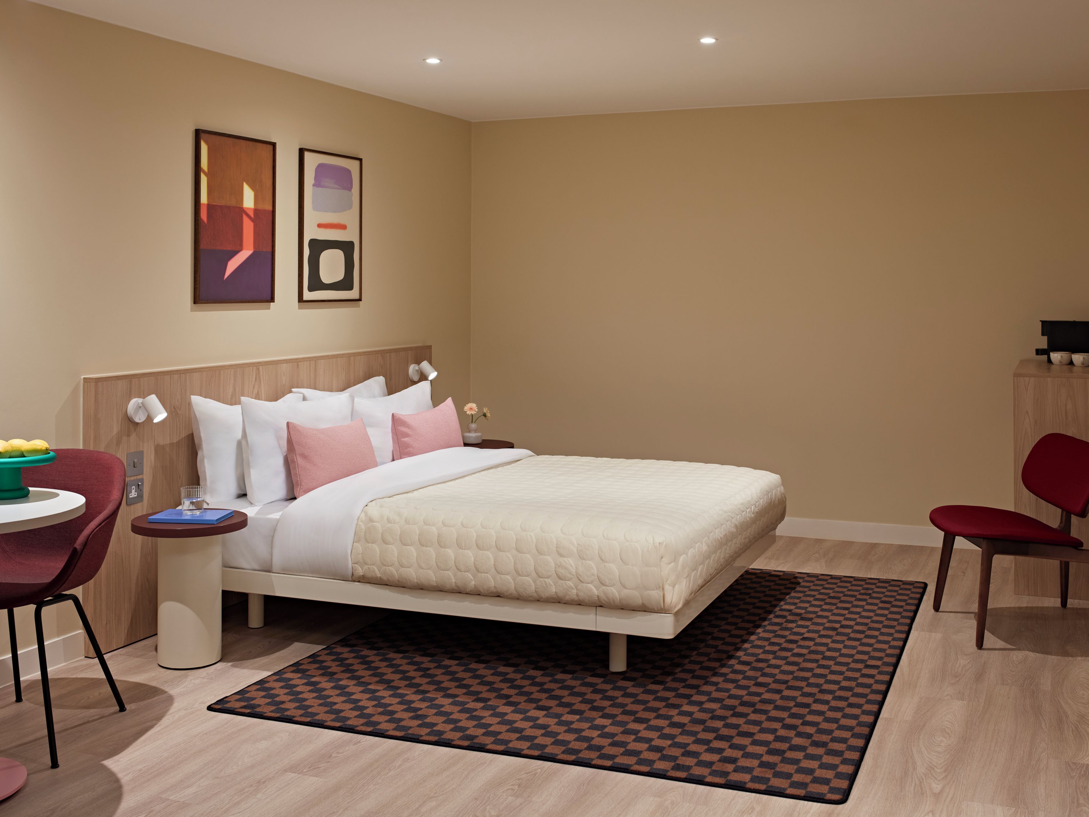 Una habitación de hotel moderna con cama, mesitas de noche, escritorio y silla.