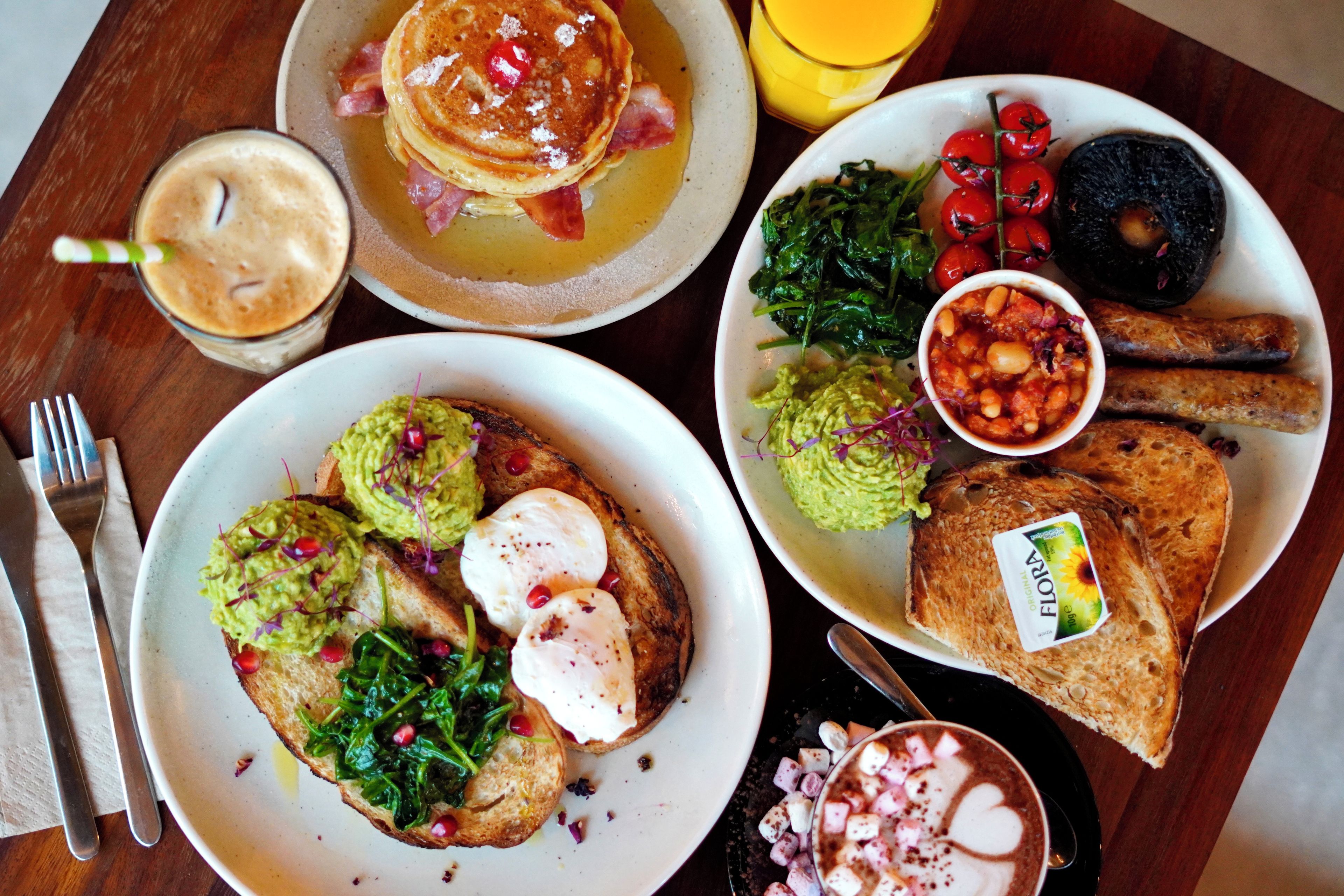 Un desayuno abundante con panqueques, huevos, tostadas y varios acompañamientos.
