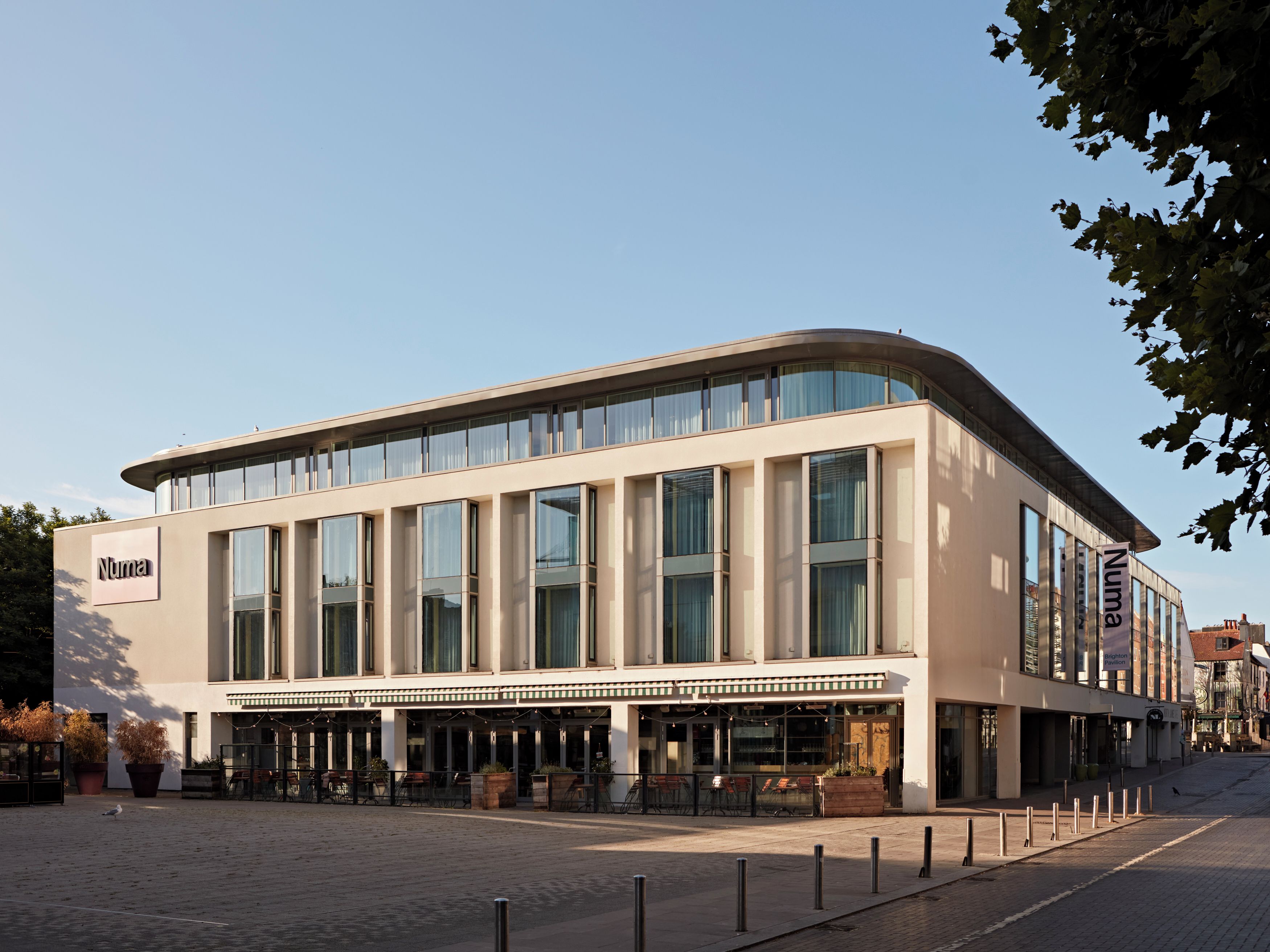 A modern building with a flat facade, large windows, and a sign that reads 'Numa.'