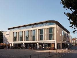 A modern building with a flat facade, large windows, and a sign that reads 'Numa.'
