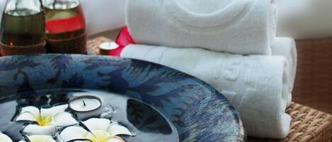 Un ambiente de spa con fuente de agua, velas y toallas.