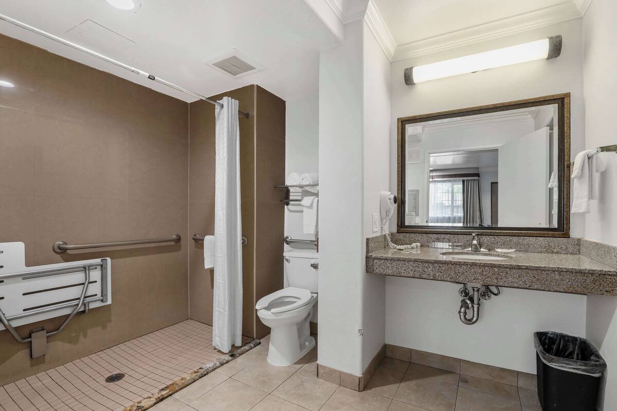A bathroom with a shower, toilet, and sink.