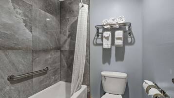 A bathroom with a bathtub, toilet, towel rack, and shower curtain.