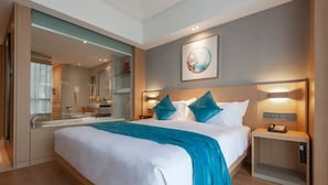 A modern hotel room with a large bed, a bathroom with a glass partition, and a painting on the wall. - Radisson Blu Hotel Shanghai Hong Quan (Shanghai)