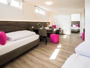 Een moderne hotelkamer met een groot bed, een bureau en een tweede bed.