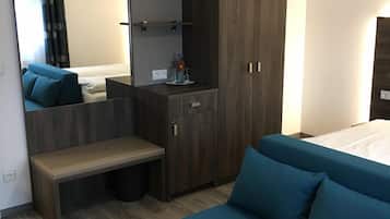 A modern bedroom with a bed, a bench, a wardrobe, and a mirror.