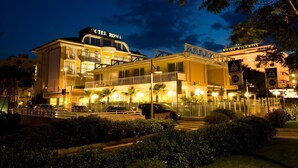 Ett hotell med en tydlig skylt som visar "HOTEL ROMA", flera balkonger och en väl upplyst entré.