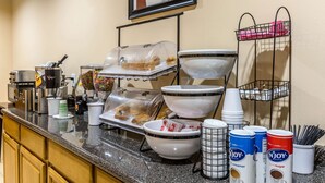 Un buffet de petit-déjeuner avec une variété d’aliments, de bols et de récipients.