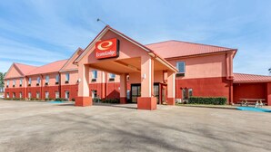 Un hôtel à la façade rouge, avec une enseigne « EconoLodge » bien visible et une entrée abritée.