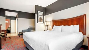 A hotel room with a large bed, a desk with a chair, a lamp, and a framed picture on the wall. - Best Western Plus Daphne Inn & Suites (Daphne)