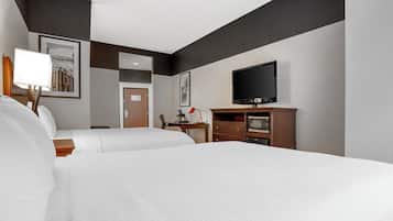 Een hotelkamer met twee bedden, een flatscreen televisie, een bureau met lamp en kunst aan de muren.