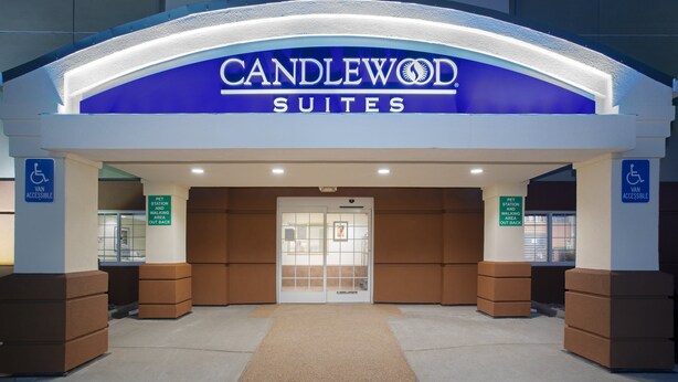 The entrance to Candlewood Suites with a pet station and van accessibility signs. - Candlewood Suites Cheyenne by IHG (Cheyenne)
