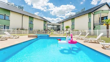 Relax by the rectangular pool surrounded by lounge chairs and a decorative float.