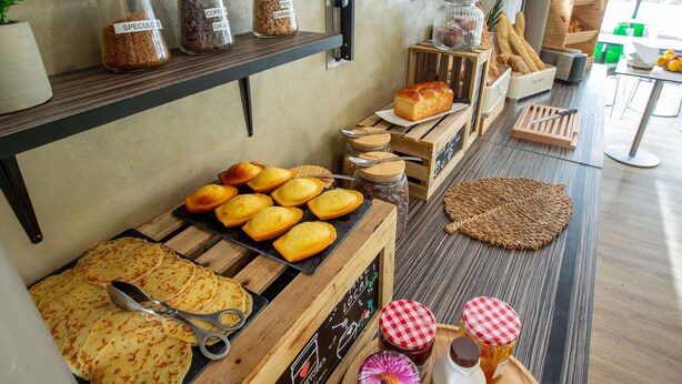 A bakery display with pastries, condiments, and a chalkboard menu. - ibis Styles Bourges (Bourges)