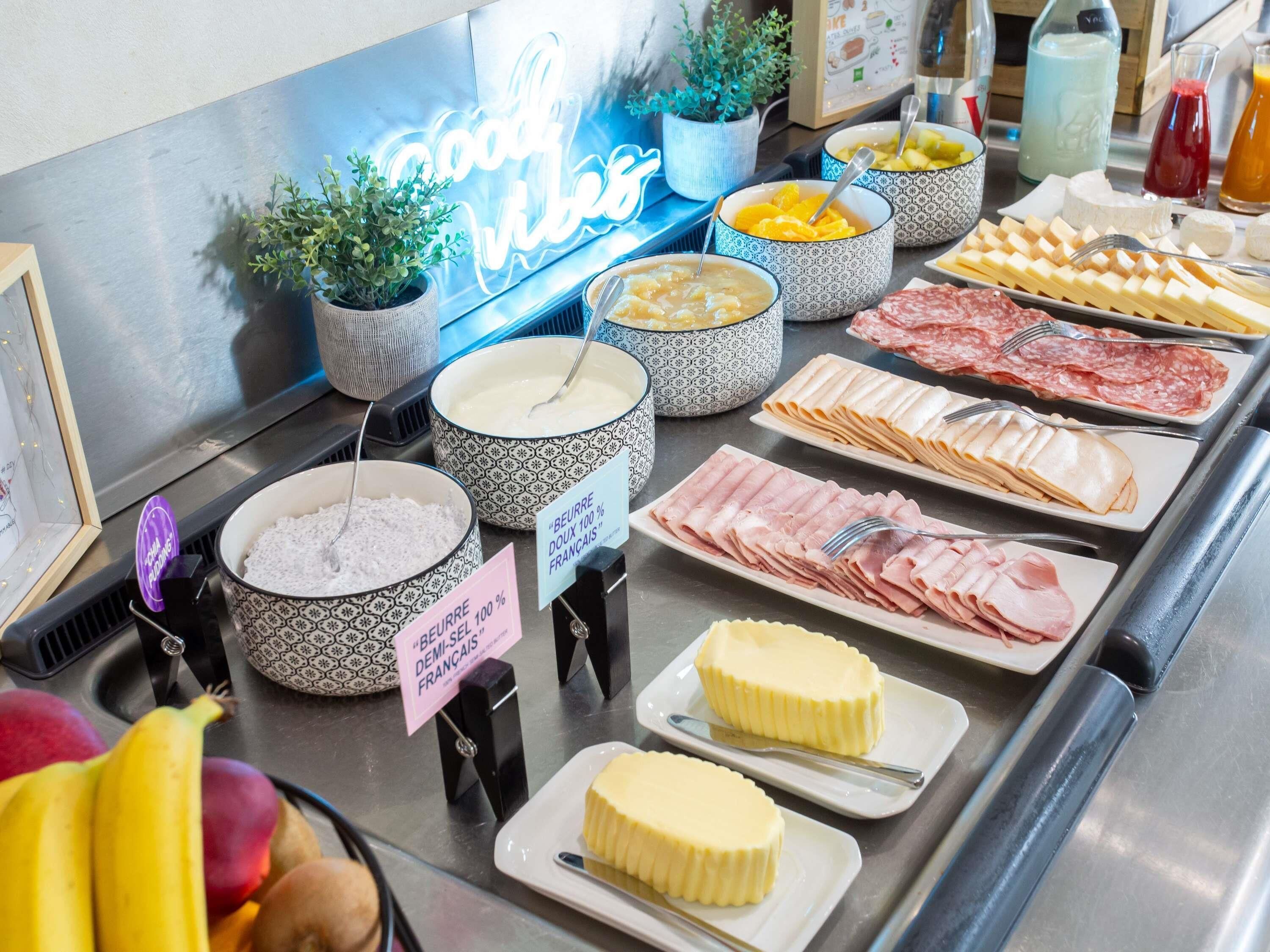 Un bufé con diferentes opciones de comida, incluyendo queso, carnes y frutas.