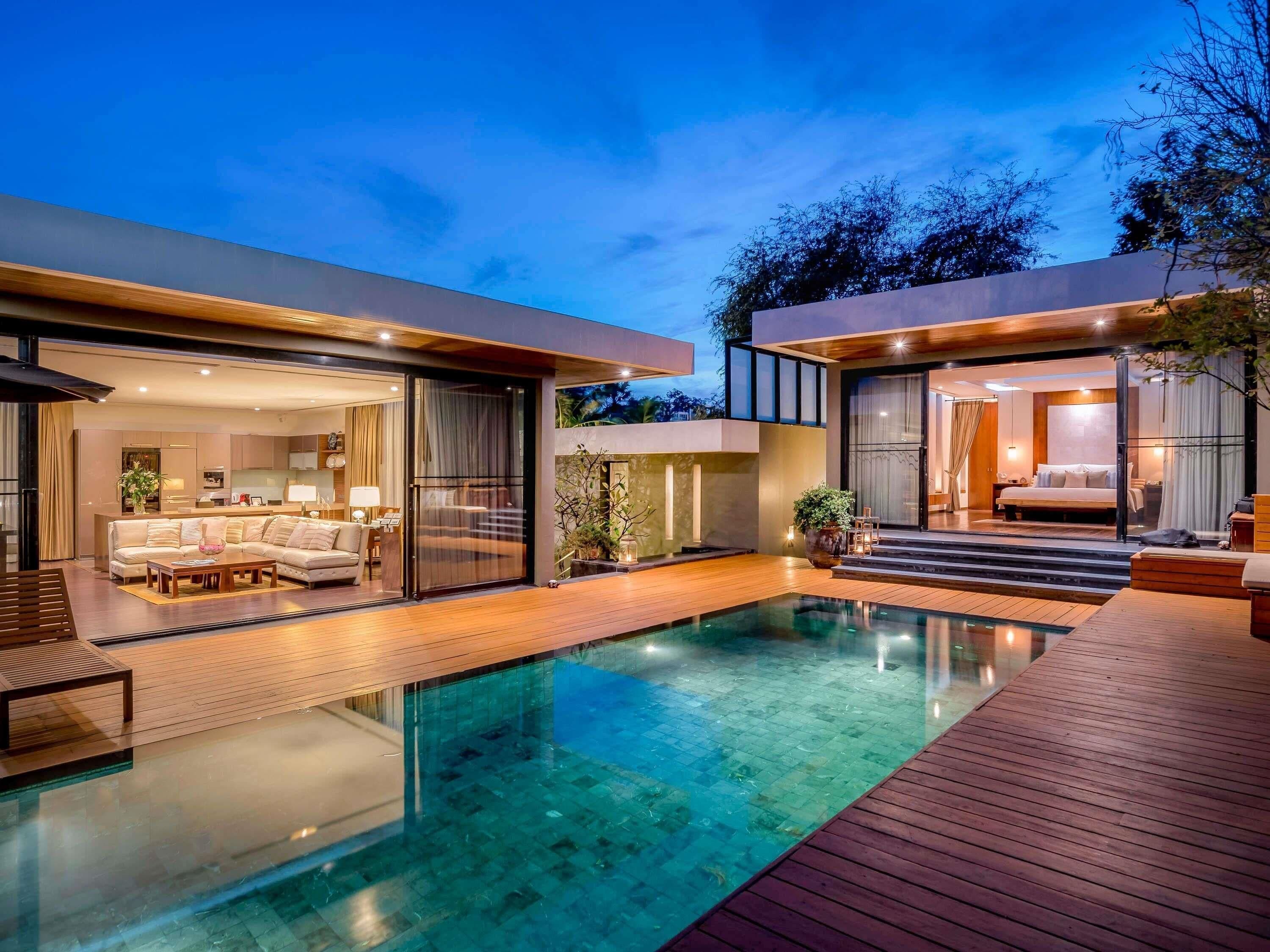 A modern house with a swimming pool, a living room, and a bedroom.
