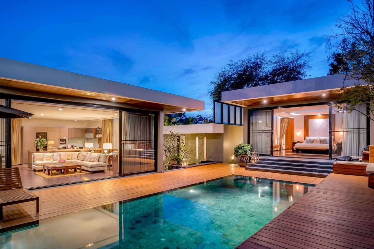 A modern house with a swimming pool, a living room, and a bedroom.