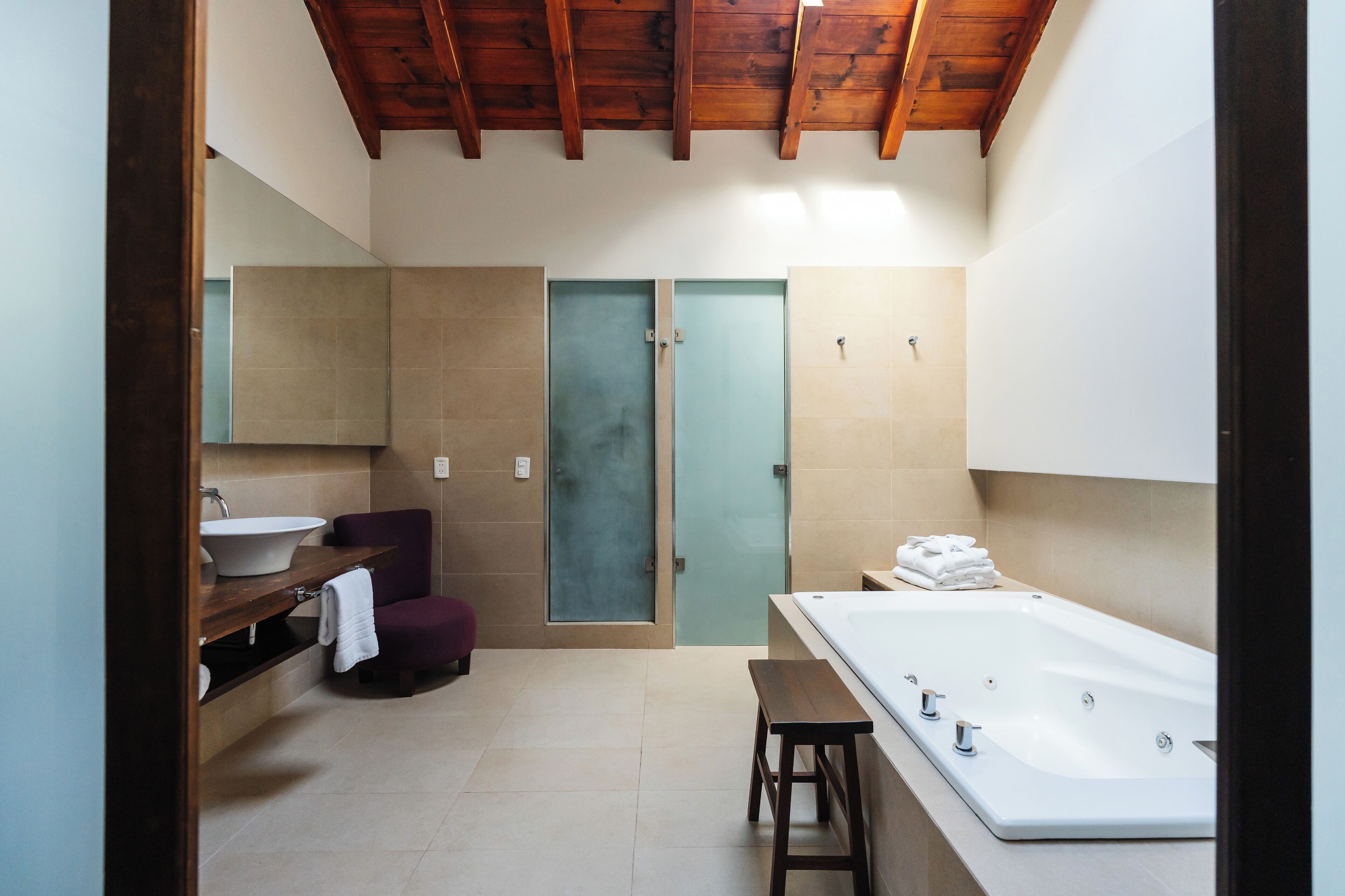 Une salle de bain moderne dotée d’une grande baignoire, d’un lavabo, d’un meuble-vasque et d’un espace douche.