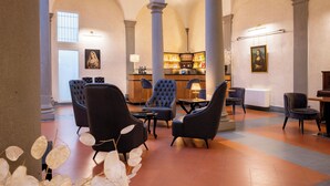 Eine Lobby mit Barbereich, Sitzgelegenheiten und Säulen.