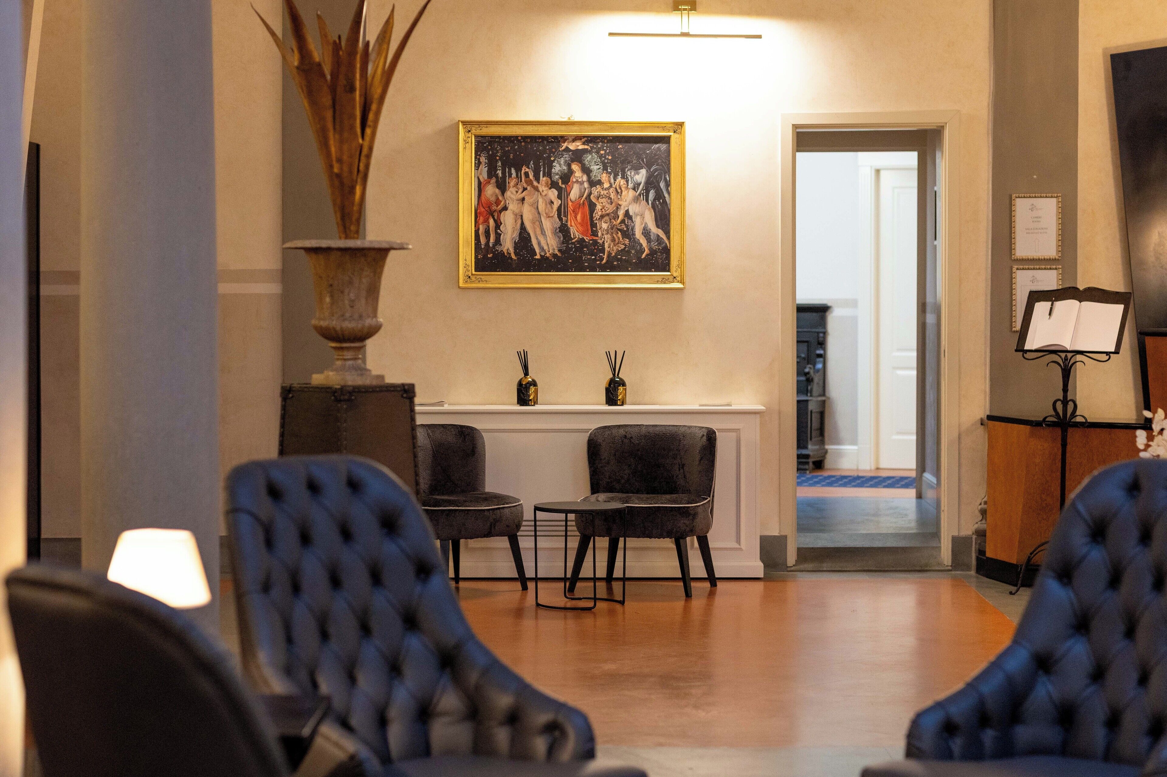 Una hall con due poltrone, un quadro di grandi dimensioni e una reception.