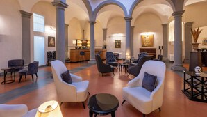 Eine großzügige Lobby mit hohen Decken, Rundbögen und gemütlichen Sitzbereichen.