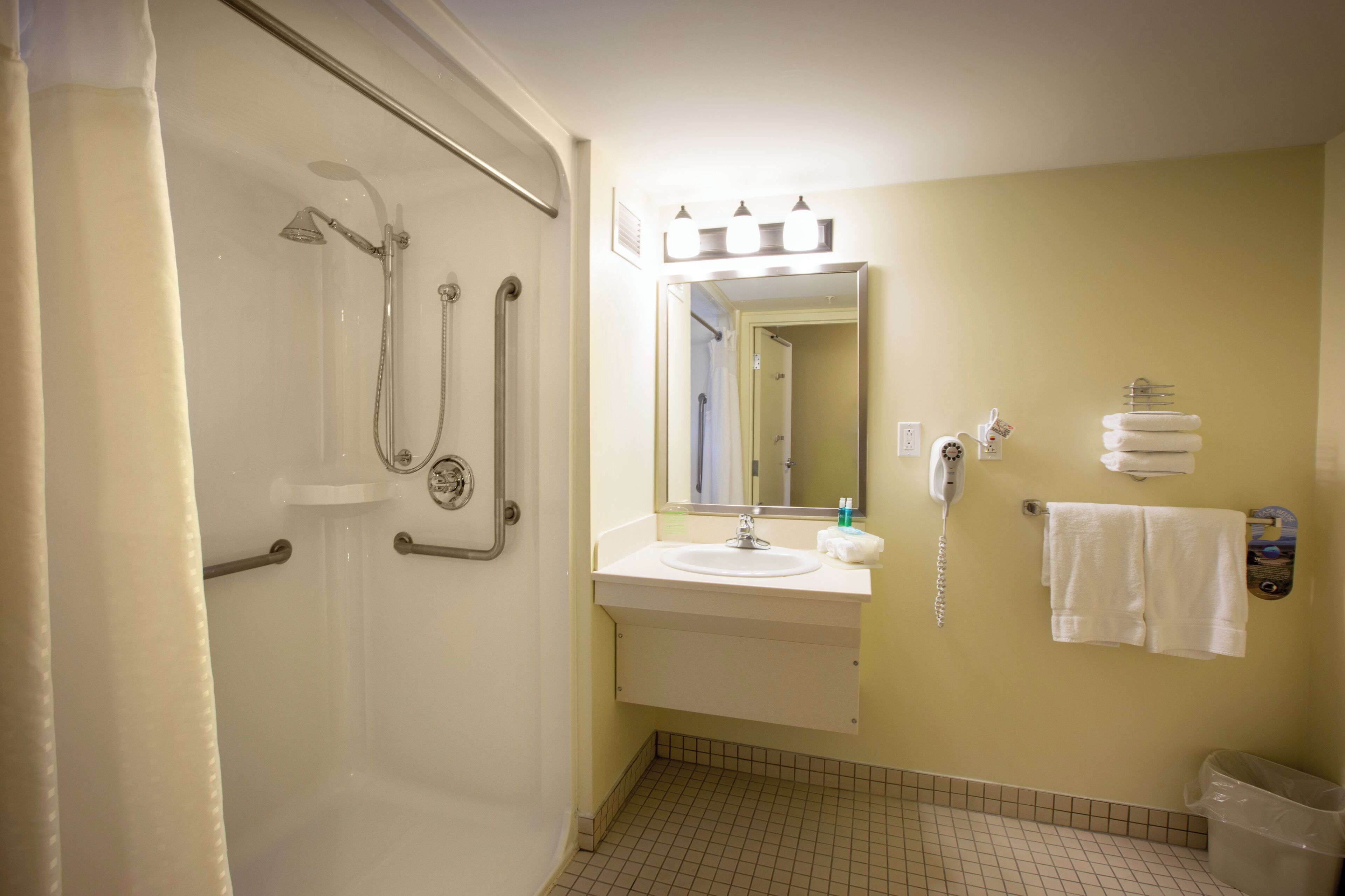 Un baño con ducha, lavabo y espejo.