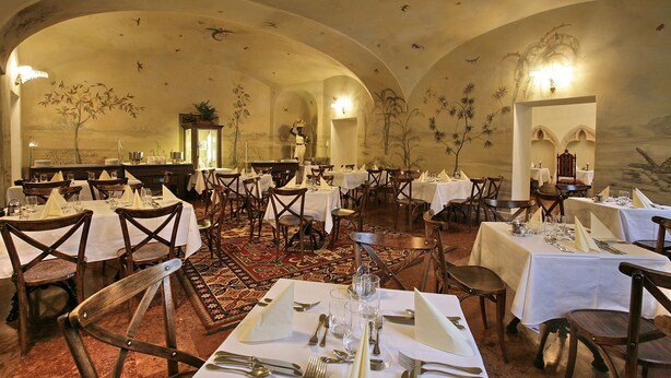 A spacious dining area with multiple tables set for dining, featuring a classic architectural design with arched ceilings and detailed wall murals. - St. George Residence All Suite Hotel Deluxe (Budapest)