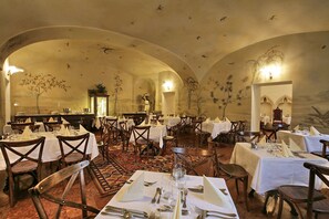 A spacious dining area with multiple tables set for dining, featuring a classic architectural design with arched ceilings and detailed wall murals. - St. George Residence All Suite Hotel Deluxe (Budapest)