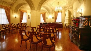 A grand hall with ornate ceilings, wooden chairs arranged in rows, a piano, and a buffet table. - St. George Residence All Suite Hotel Deluxe (Budapest)