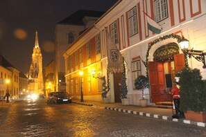 A historic building with a prominent tower, a restaurant named 'George Residence Restaurant', and a Christmas tree decoration. - St. George Residence All Suite Hotel Deluxe (Budapest)