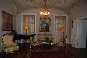 A room with ornate furniture, a chandelier, and a large painting on the wall. - St. George Residence All Suite Hotel Deluxe (Budapest)