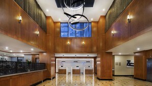 A spacious lobby with a check-in counter, a reception desk, and a modern ceiling design. - Hilton Garden Inn Montréal Centre-ville (Montreal)