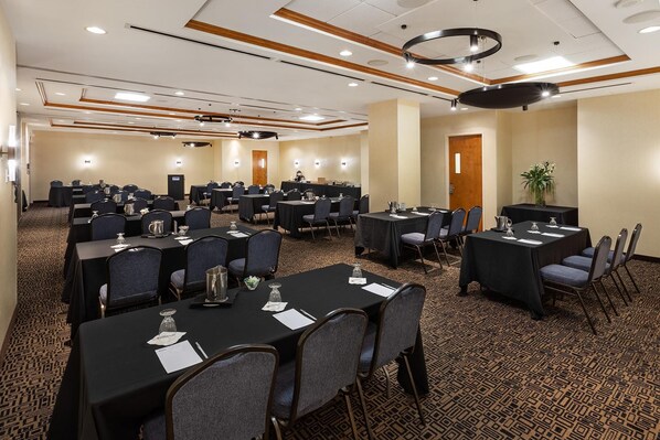 A conference room with multiple tables and chairs, equipped with nameplates and water pitchers. - Hilton Garden Inn Montréal Centre-ville (Montreal)