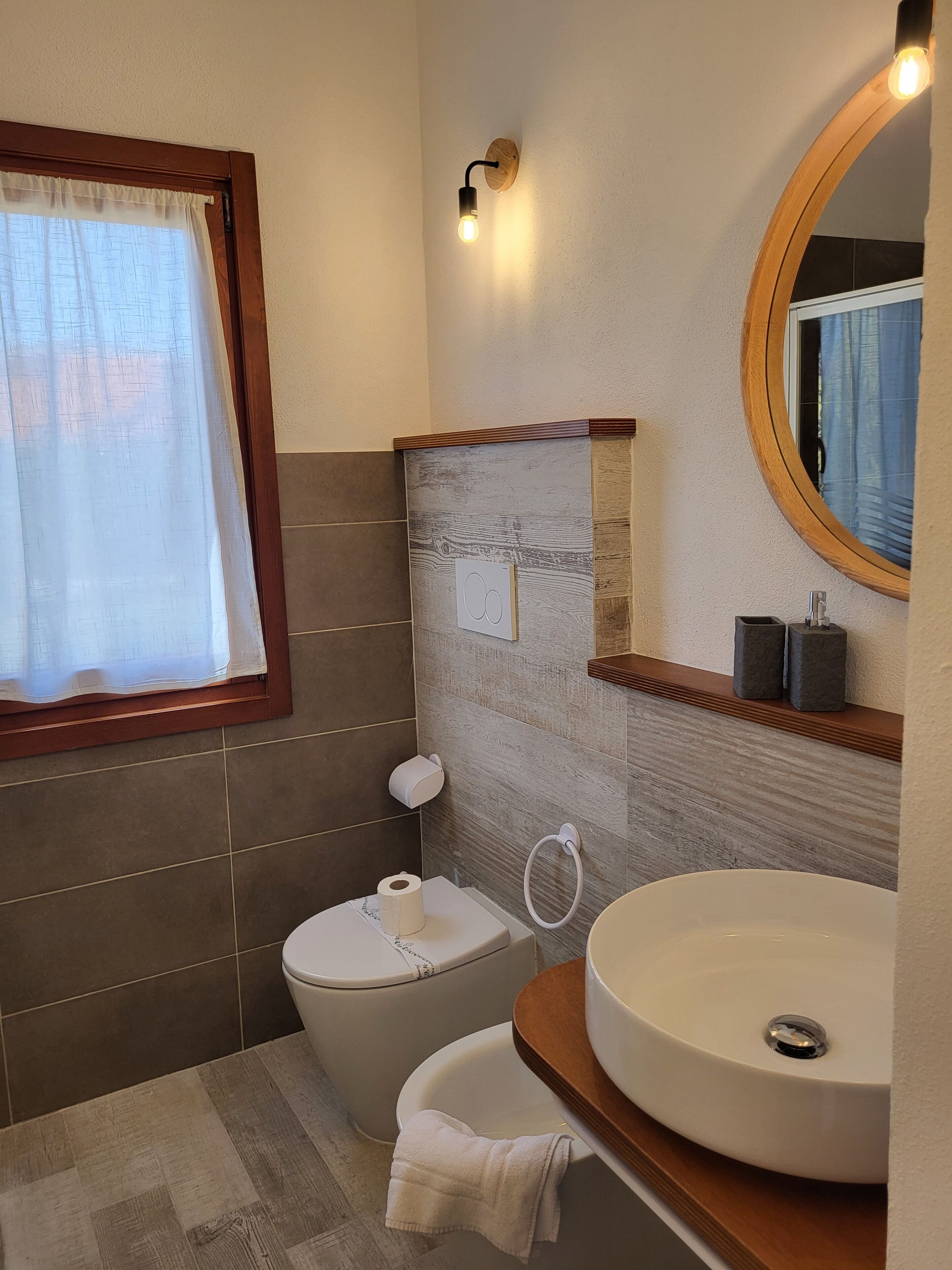 A bathroom with a toilet, sink, and a mirror.