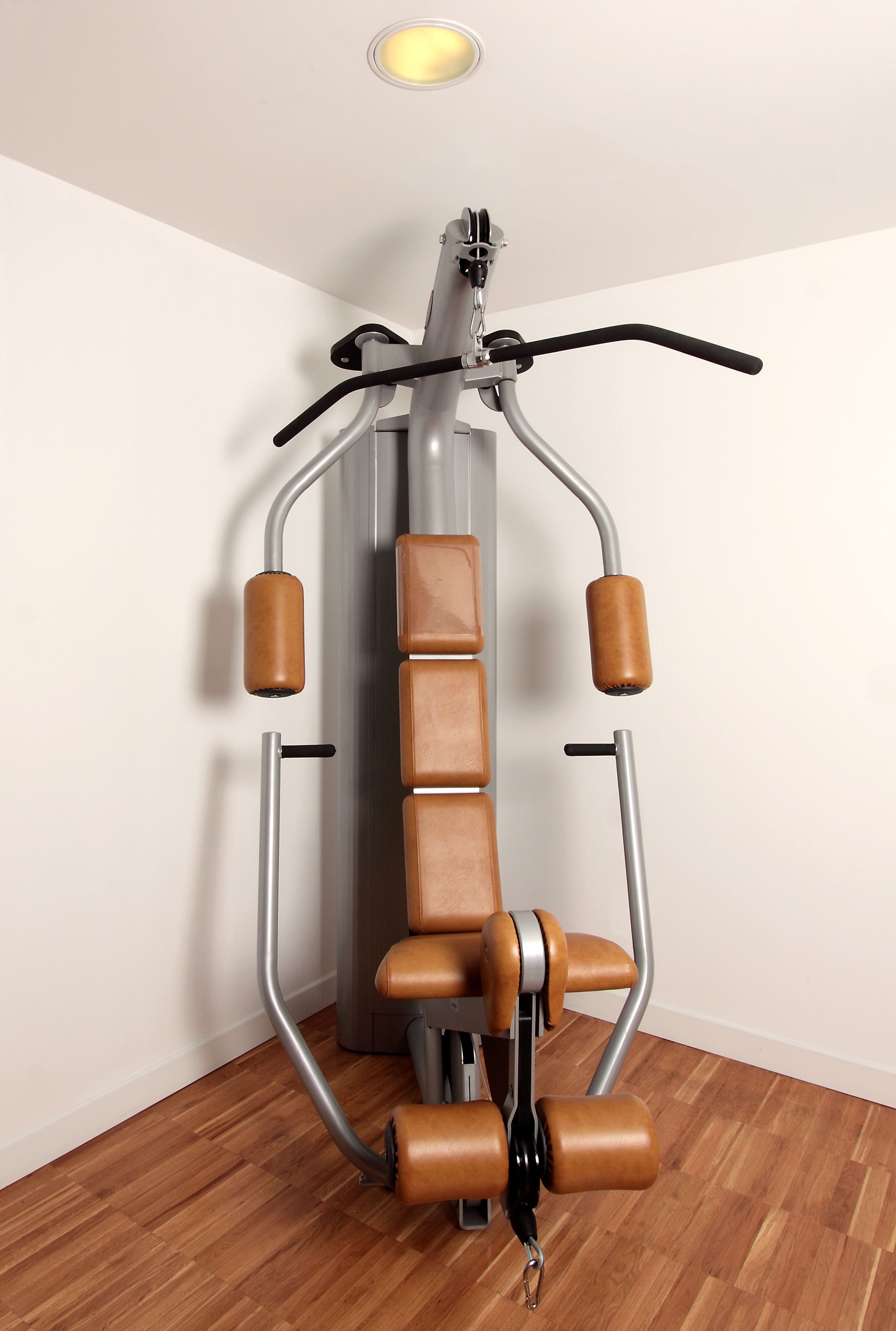 A stationary exercise machine with a handlebar, padded seat, and foot pedals.