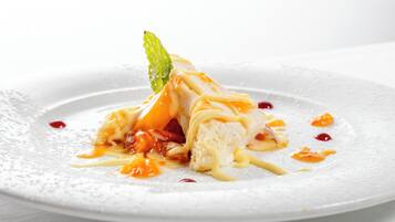 A dessert on a white plate with a mint leaf garnish.