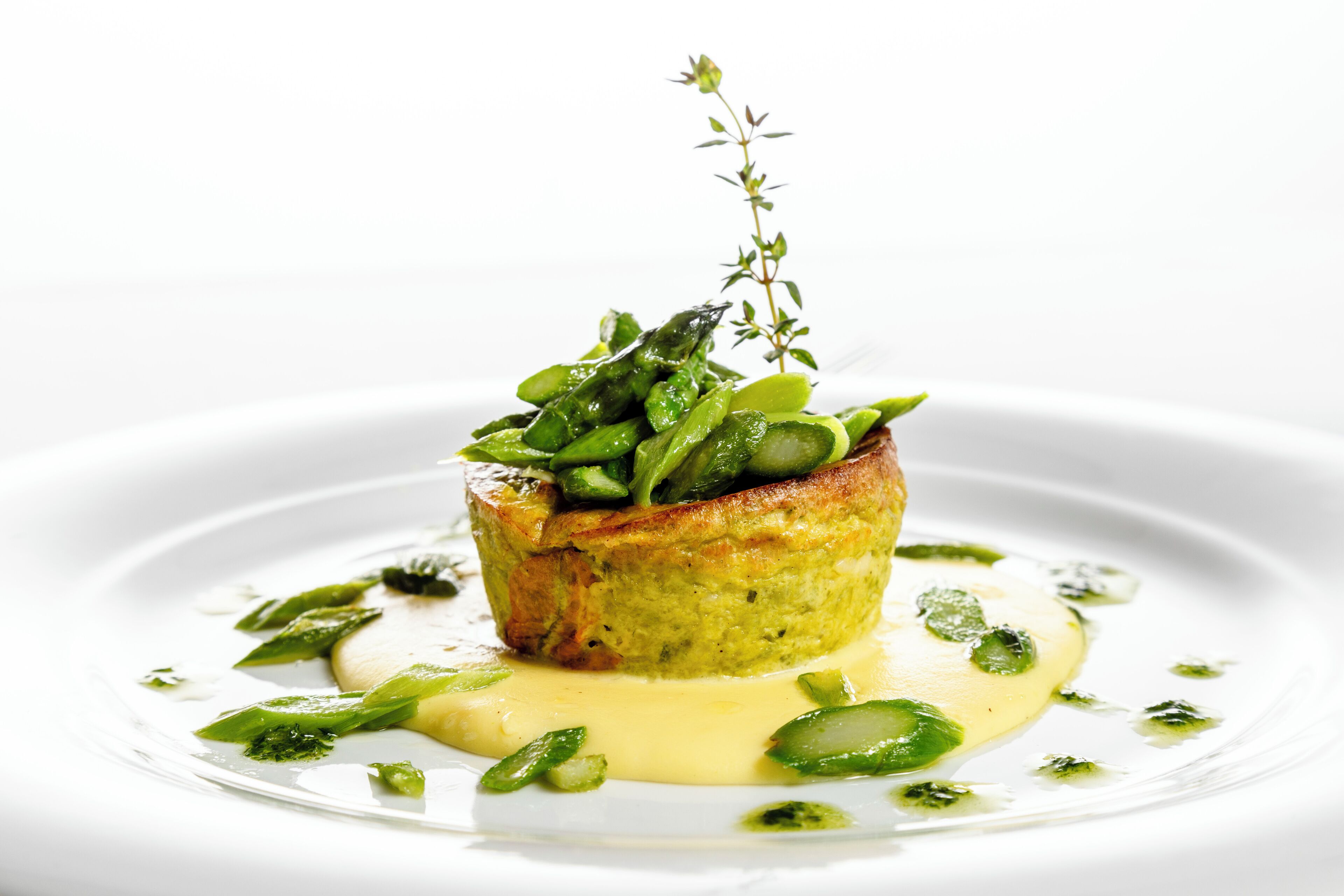 Un plato con salsa verde y verduras verdes.
