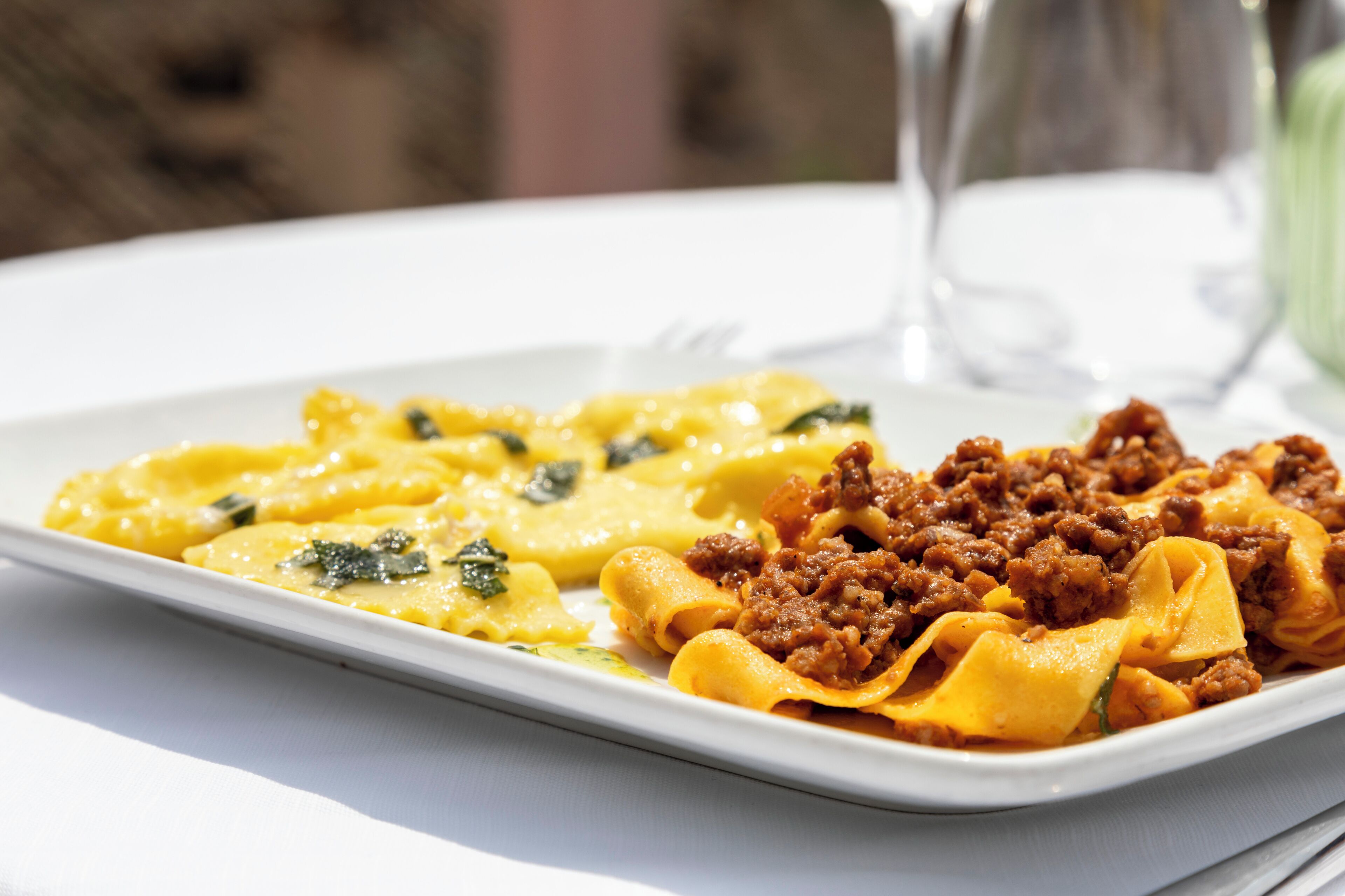 Un plato de pasta con salsa cremosa y carne molida, sobre un plato blanco.