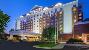 A large, multi-story hotel with a prominent 'Hilton' sign, a covered entrance, and a well-lit facade. - Hilton Columbus/Polaris (Columbus)