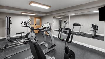Ein Fitnessstudio mit Laufbändern, Crosstrainern und Kraftgeräten.