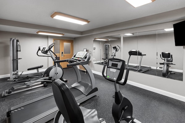 A gym with treadmills, elliptical machines, and weight equipment.